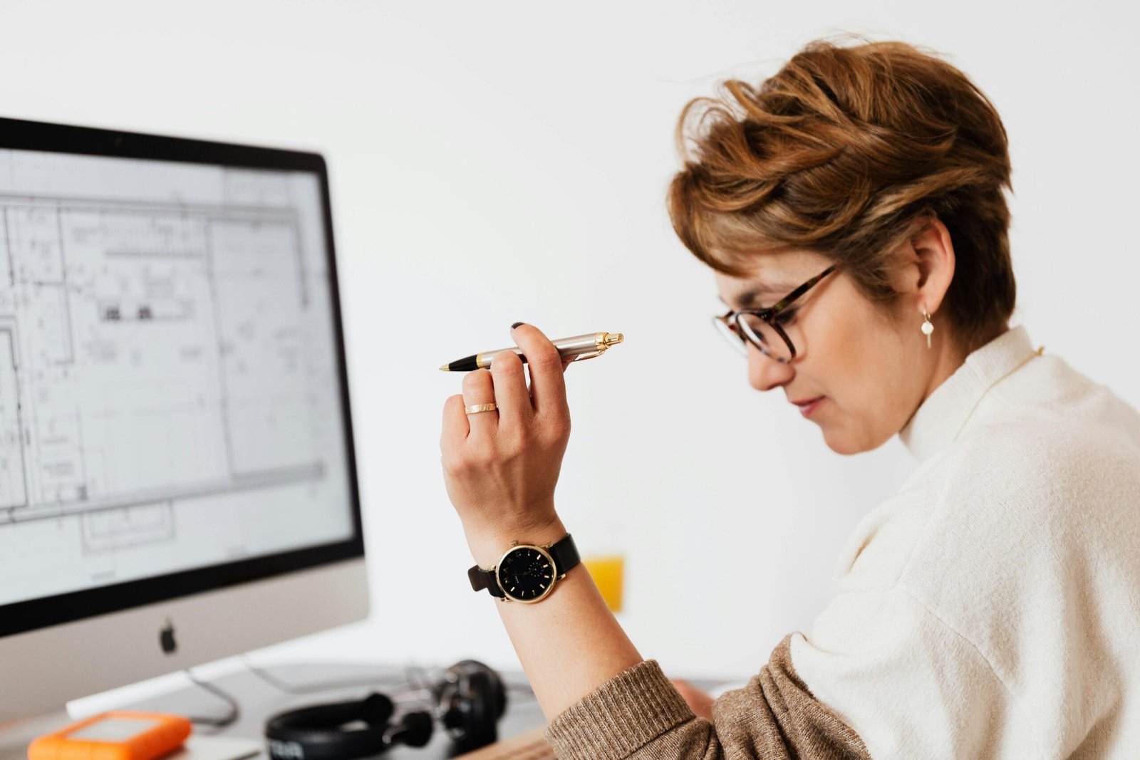 Confident businesswoman using computer for architectural analysis in a modern office.