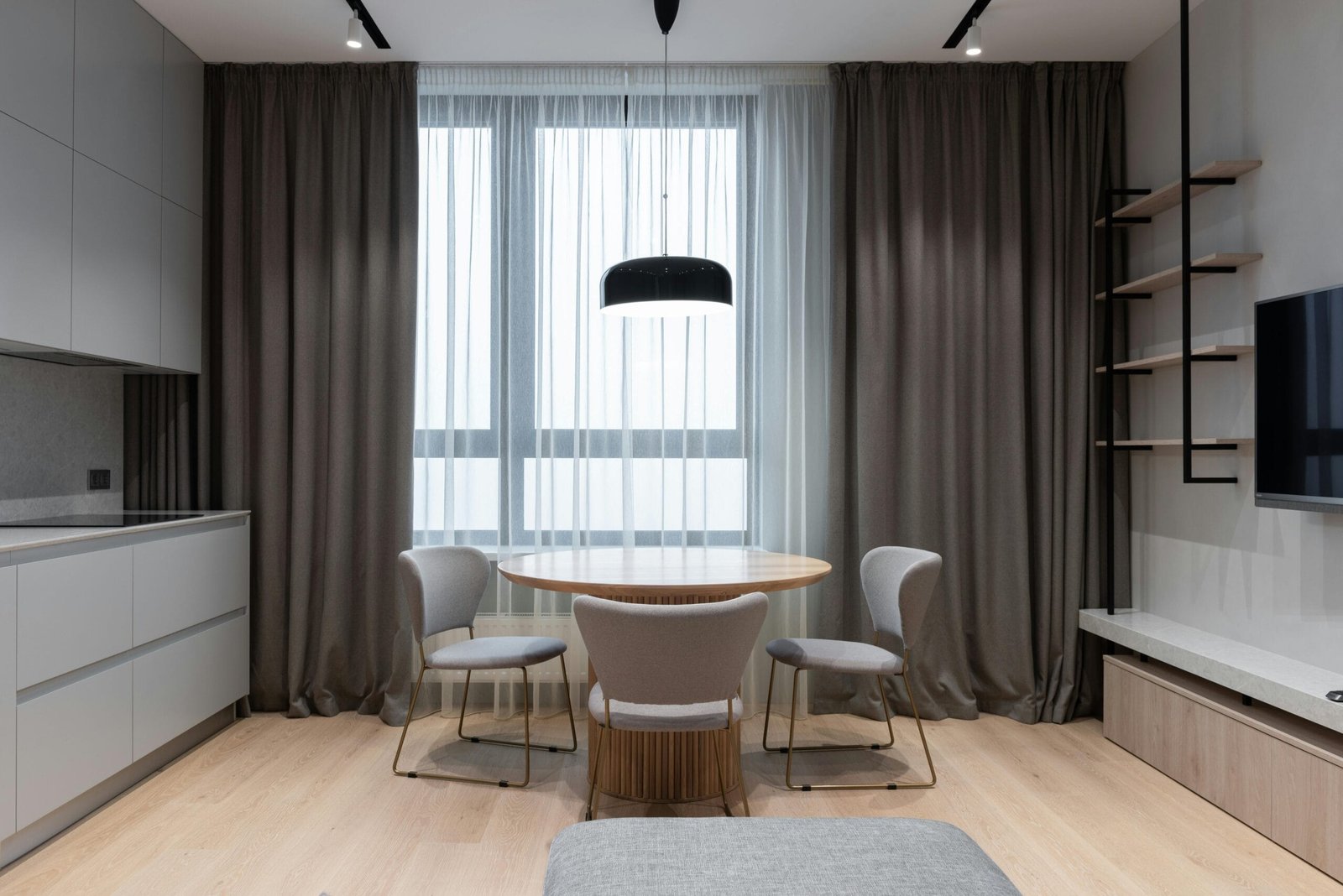 A sleek and modern interior of an apartment with natural light flooding through large windows.